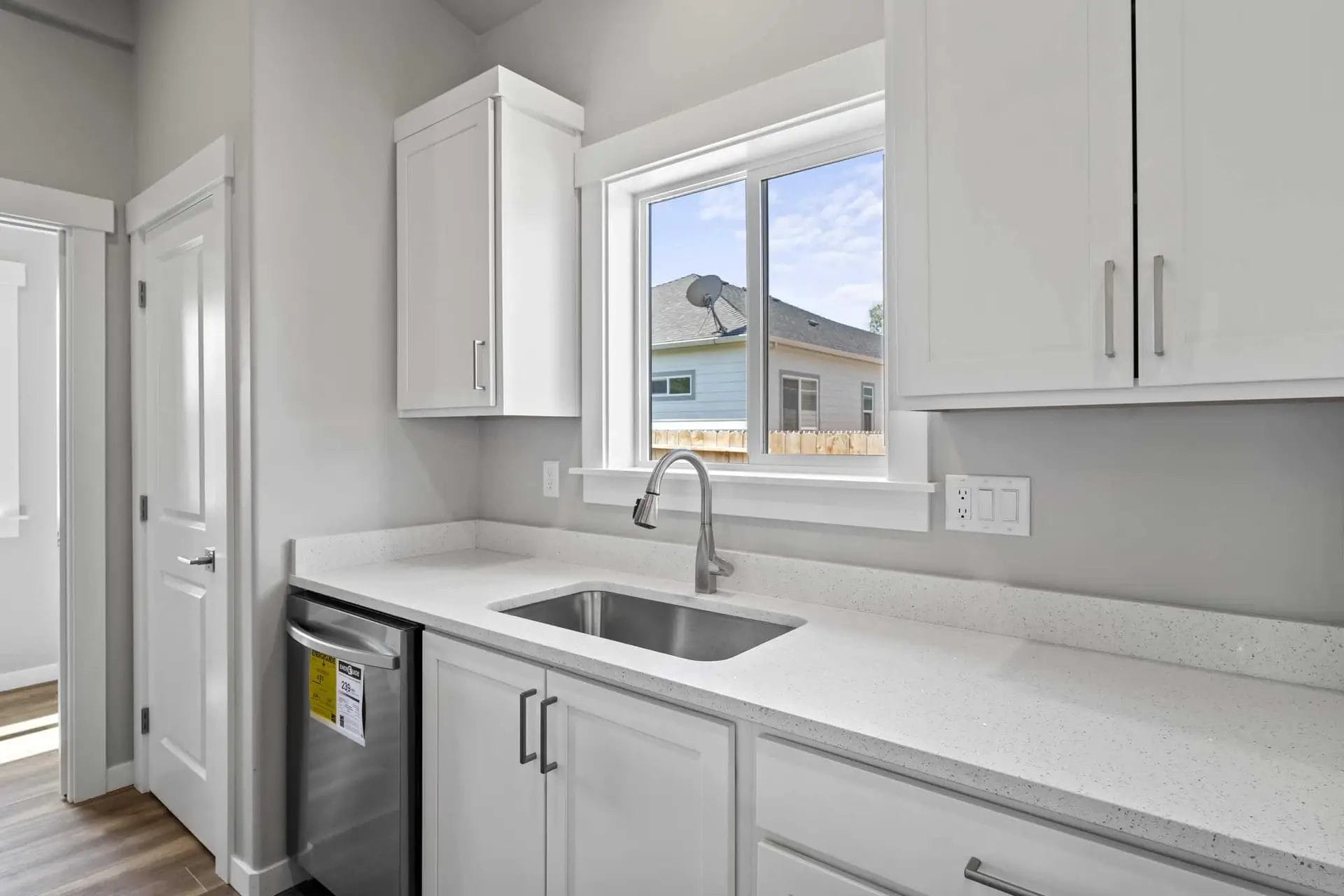 A Bright White Kitchen with Crisp Cabinets, Gleaming Countertops, and a Stunning Sink