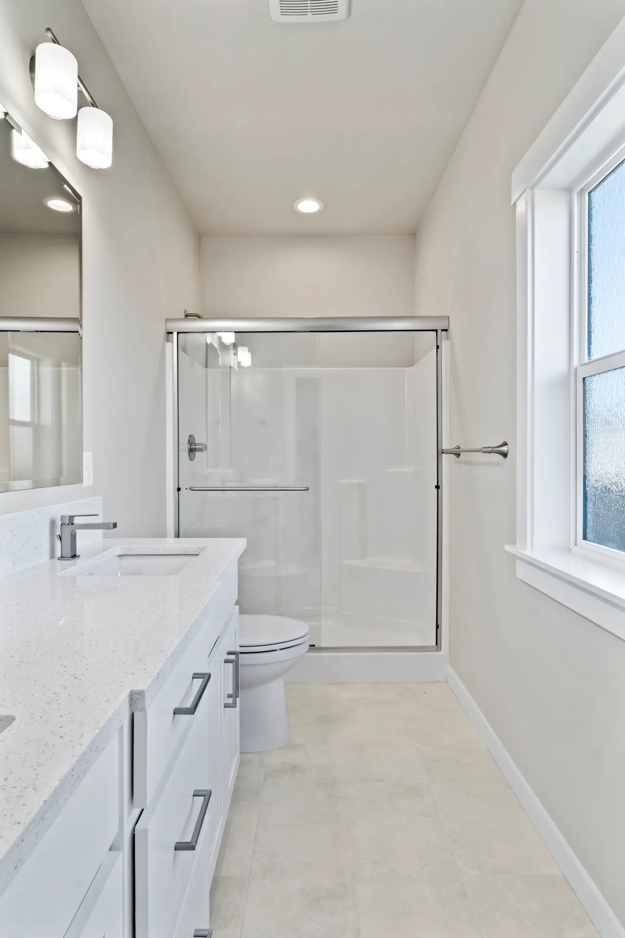 a master bathroom with a serene ambiance. the room features pristine white countertops, a sleek sink, and a stylish mirror that complements the overall aesthetic. A refreshing shower